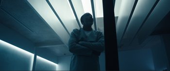 Movie still from “Assassin's Creed” (2016), directed by Justin Kurzel – A man standing with his arms crossed in a dark room; Medium shot, Low angle