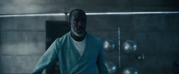 Movie still from “Assassin's Creed” (2016), directed by Justin Kurzel – A man standing in front of a bunch of metal balls; Medium shot, Low angle