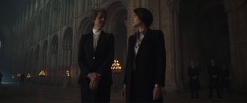 Movie still from “Assassin's Creed” (2016), directed by Justin Kurzel – Two women standing next to each other in front of a building; Medium shot, Low angle