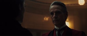 Movie still from “Assassin's Creed” (2016), directed by Justin Kurzel – An older man wearing a suit and a tie; Close Up shot, Over the shoulder angle