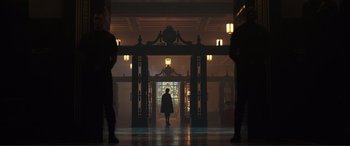 Movie still from “Assassin's Creed” (2016), directed by Justin Kurzel – A person is walking through a doorway in a building; Extreme Wide shot, Low angle