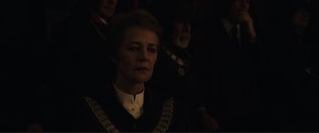 Movie still from “Assassin's Creed” (2016), directed by Justin Kurzel – An older woman in a black outfit is looking into the distance; Close Up shot, Over the shoulder angle