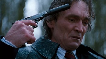 Movie still from “Assassins” (1995), directed by Richard Donner – A man holding a gun up to his head; Close Up shot, Low angle