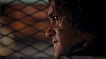 Movie still from “Assassins” (1995), directed by Richard Donner – A man's face in front of a chain link fence; Close Up shot, Low angle