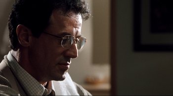 Movie still from “Assassins” (1995), directed by Richard Donner – A person wearing glasses; Close Up shot, Over the shoulder angle