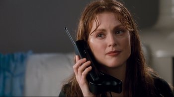 Movie still from “Assassins” (1995), directed by Richard Donner – A woman holding a phone up to her ear; Close Up shot, Low angle