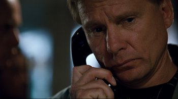 Movie still from “Assassins” (1995), directed by Richard Donner – A person talking on a cell phone; Close Up shot, Low angle