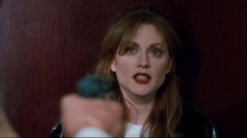 Movie still from “Assassins” (1995), directed by Richard Donner – A person holding a gun in a room; Close Up shot, Over the shoulder angle
