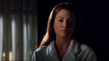 Movie still from “Assassins” (1995), directed by Richard Donner – A woman in a white robe is looking at the camera; Close Up shot, Over the shoulder angle