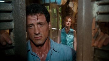 Movie still from “Assassins” (1995), directed by Richard Donner – A man and a woman standing next to each other; Close Up shot, Low angle