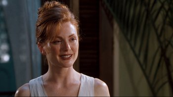 Movie still from “Assassins” (1995), directed by Richard Donner – A person with red hair smiling; Close Up shot, Over the shoulder angle
