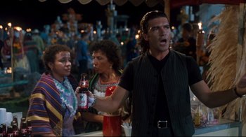 Movie still from “Assassins” (1995), directed by Richard Donner – A group of people standing next to each other on the street; Medium shot, Over the shoulder angle