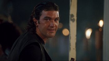 Movie still from “Assassins” (1995), directed by Richard Donner – A person with long black hair; Close Up shot, Low angle