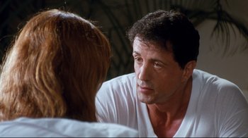 Movie still from “Assassins” (1995), directed by Richard Donner – A man and a woman are talking to each other; Close Up shot, Over the shoulder angle