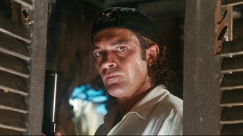 Movie still from “Assassins” (1995), directed by Richard Donner – A person wearing a hat; Close Up shot, Low angle