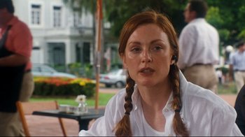 Movie still from “Assassins” (1995), directed by Richard Donner – A woman with red hair sitting in front of a table; Close Up shot, Over the shoulder angle