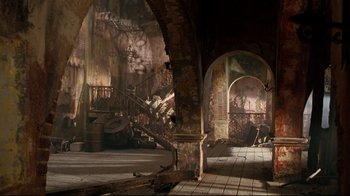 Movie still from “Assassins” (1995), directed by Richard Donner – An arched doorway in an abandoned building; Extreme Wide shot, Low angle