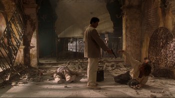Movie still from “Assassins” (1995), directed by Richard Donner – A man holding an umbrella standing in an abandoned building; Wide shot, Low angle