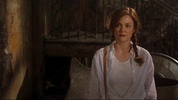 Movie still from “Assassins” (1995), directed by Richard Donner – A woman with red hair and a white shirt; Medium shot, Over the shoulder angle