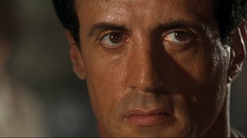 Movie still from “Assassins” (1995), directed by Richard Donner – A man's face with brown eyes; Extreme Close Up shot, Low angle