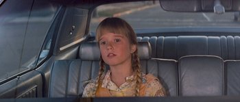 Movie still from “Assault on Precinct 13” (1976), directed by John Carpenter – A young girl sitting in the back seat of a car; Close Up shot, Over the shoulder angle