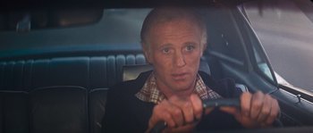 Movie still from “Assault on Precinct 13” (1976), directed by John Carpenter – A man sitting in the back seat of a car; Close Up shot, Over the shoulder angle