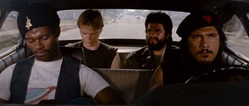 Movie still from “Assault on Precinct 13” (1976), directed by John Carpenter – Two people sitting in a car looking at a laptop; Medium shot, Over the shoulder angle