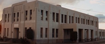Movie still from “Assault on Precinct 13” (1976), directed by John Carpenter – A large building with a clock on the front of the building; Extreme Wide shot, Low angle