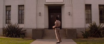 Movie still from “Assault on Precinct 13” (1976), directed by John Carpenter – A police officer standing in front of a door way; Wide shot, Low angle