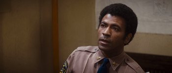 Movie still from “Assault on Precinct 13” (1976), directed by John Carpenter – A man in a police uniform looking to his left; Close Up shot, Low angle