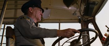 Movie still from “Assault on Precinct 13” (1976), directed by John Carpenter – An older man driving a truck with a hat on; Medium shot, Low angle