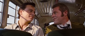 Movie still from “Assault on Precinct 13” (1976), directed by John Carpenter – A couple of men sitting next to each other on top of a bus; Close Up shot, Over the shoulder angle