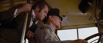 Movie still from “Assault on Precinct 13” (1976), directed by John Carpenter – Two men are sitting in a bus together; Medium shot, Low angle