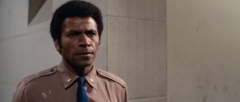 Movie still from “Assault on Precinct 13” (1976), directed by John Carpenter – A person wearing a suit and tie; Close Up shot, Low angle