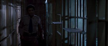 Movie still from “Assault on Precinct 13” (1976), directed by John Carpenter – A man standing in front of a jail cell; Medium shot, High angle