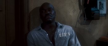 Movie still from “Assault on Precinct 13” (1976), directed by John Carpenter – A man in a blue button up shirt is posing for a picture; Close Up shot, High angle