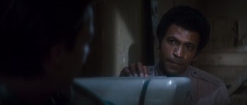 Movie still from “Assault on Precinct 13” (1976), directed by John Carpenter – A man sitting at a sink in the dark; Close Up shot, Over the shoulder angle