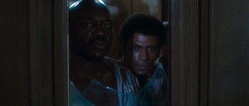 Movie still from “Assault on Precinct 13” (1976), directed by John Carpenter – Two black men standing next to each other in front of a mirror; Close Up shot, High angle