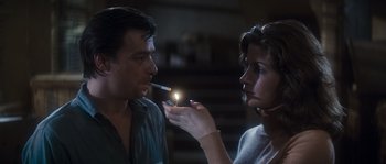 Movie still from “Assault on Precinct 13” (1976), directed by John Carpenter – A woman lighting a cigarette from a man's mouth; Close Up shot, Over the shoulder angle
