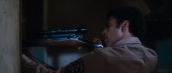 Movie still from “Assault on Precinct 13” (1976), directed by John Carpenter – A man is holding a rifle and aiming it; Close Up shot, Low angle