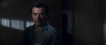 Movie still from “Assault on Precinct 13” (1976), directed by John Carpenter – A man standing in front of a door with a light on; Close Up shot, Over the shoulder angle