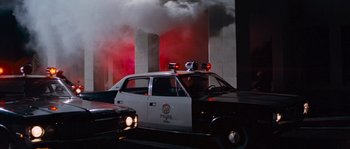 Movie still from “Assault on Precinct 13” (1976), directed by John Carpenter – A police car is parked on the side of the road; Wide shot, Low angle
