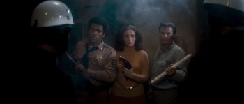 Movie still from “Assault on Precinct 13” (1976), directed by John Carpenter – A group of men and women standing next to each other holding guns; Medium shot, High angle