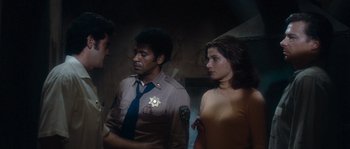 Movie still from “Assault on Precinct 13” (1976), directed by John Carpenter – A group of men and women standing next to each other; Medium shot, Over the shoulder angle