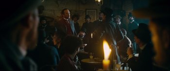 Movie still from “At Eternity's Gate” (2018), directed by Julian Schnabel – A group of people sitting at a table with candles; Wide shot, Over the shoulder angle
