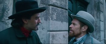 Movie still from “At Eternity's Gate” (2018), directed by Julian Schnabel – Two men in hats are standing next to each other; Medium shot, Over the shoulder angle