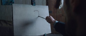 Movie still from “At Eternity's Gate” (2018), directed by Julian Schnabel – A person holding a paint brush in front of an easel; Extreme Close Up shot, High angle