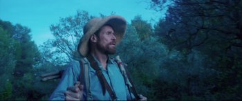 Movie still from “At Eternity's Gate” (2018), directed by Julian Schnabel – A man in a straw hat is standing in the woods; Medium shot, Low angle