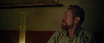 Movie still from “At Eternity's Gate” (2018), directed by Julian Schnabel – A man with a beard is sitting in front of a wall; Close Up shot, Over the shoulder angle
