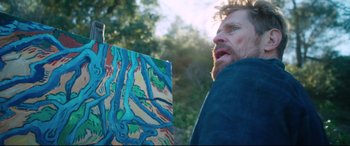 Movie still from “At Eternity's Gate” (2018), directed by Julian Schnabel – A man holding up a painting in front of trees; Medium shot, Over the shoulder angle
